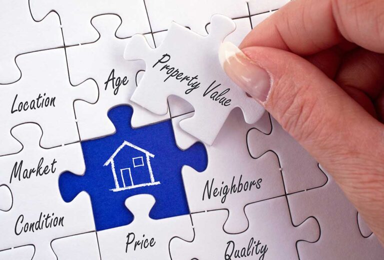 A person tidying a living room and packing boxes in a well-lit, lived-in home preparing for sale.